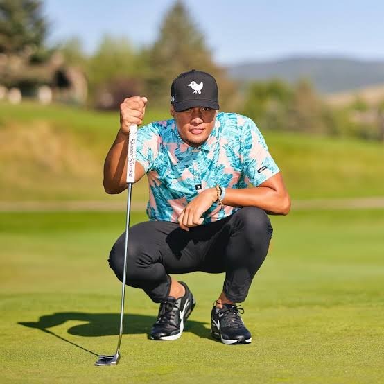 Golfer wearing a blue Bad Birdie printed polo while reading a putting line