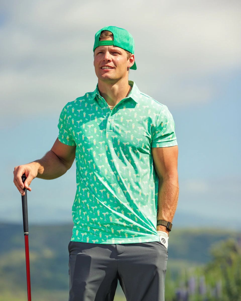 Man wearing green Sunday Swagger Off The Clock printed golf polo