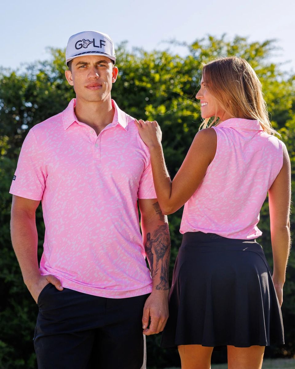 Man and woman wearing coordinated pink Sunday Swagger Pink Painter golf polos